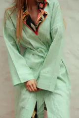 Bata de lino con diseño a rayas verticales en tonos verde menta y azul, de corte holgado, manga larga y lazo ajustable en la cintura.