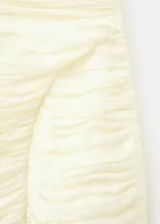 Vestido corto drapeado de color amarillo claro, con escote en V, tirantes finos y diseño entallado.