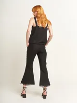 Musculosa verde agua con escote en V, breteles anchos con detalle de argollas de madera y ruedo con flecos.