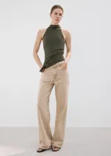 Jeans de denim color beige, de tiro medio y corte recto estilo wide leg, con diseño clásico de cinco bolsillos y cierre frontal de botón y cremallera.