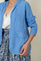 Blazer celeste de lino con corte recto, cuello mao y aplique desflecado en cuello y ruedo.