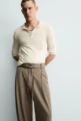 Pantalón de corte balloon fit en color gris, confeccionado en tejido con viscosa. Presenta pliegues frontales, cintura con cinturón integrado a contraste, bolsillos laterales y bolsillos traseros de vivo.