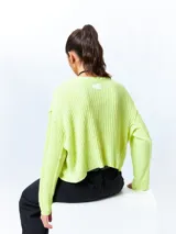 Sweater color crema de tejido de punto acanalado, corte cropped, cuello redondo y mangas largas.