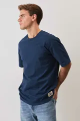 Remera marrón de manga corta, con cuello redondo y diseño holgado.