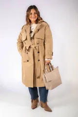 Trench coat color camel, de corte clásico con doble botonadura, solapas amplias, cinturón ajustable en la cintura y trabillas en los puños.
