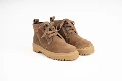 Bota acordonada de cuero color arena, con interior forrado en tela escocesa roja y negra, y suela de goma color caramelo.