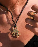 Anillo de diseño orgánico y macizo con forma irregular, elaborado en metal con acabado brillante. Presenta una estructura abierta que permite su ajuste.