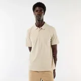 Remera polo de piqué color beige, de manga corta, con cuello camisero y cierre frontal de tres botones.