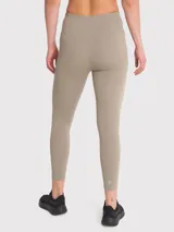 Calza deportiva color beige, tiro alto, con bolsillos laterales y banda de silicona en la cintura.