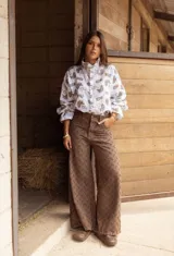 Pantalón de jean color chocolate, de corte ancho y tiro medio, con textura de rayas diagonales desgastadas en toda la prenda.