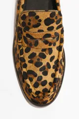 Mocasines de cuero con textura de pelo y estampado de leopardo, con diseño clásico de lengüeta decorativa y costuras frontales.
