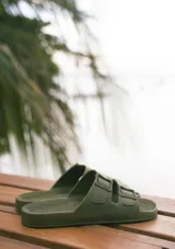 Sandalias planas color ladrillo, con doble tira ancha sobre el empeine y plantilla anatómica. Fabricadas en Brasil con materiales veganos y procesos sostenibles.