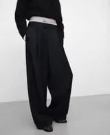 Pantalón ancho negro con pinzas en el delantero, bolsillos laterales y de vivo en la espalda, de pierna recta y tiro alto con cinturilla interior en tejido de rayas a contraste.