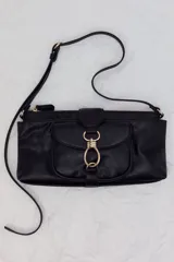 Cartera de hombro de diseño rectangular alargado, confeccionada en tejido revestido de color negro con herrajes metálicos dorados. Cuenta con un compartimento exterior con solapa y cierre de argolla metálica, cierre superior con cremallera y asa ajustable.