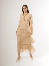 Vestido largo color beige de seda italiana, con falda de volados y sobrecapa superior. Confeccionado en tejido liviano y fluido con diseño elastizado.