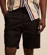Bermuda básica masculina confeccionada en sarga de algodón, de corte recto con trabillas en la cintura, bolsillos y cierre frontal con botón y cremallera.