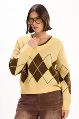 Sweater tejido con escote en V y diseño de rombos en colores amarillo y marrón. Presenta un calce relajado y puños acanalados.