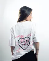 Remera blanca de algodón con estampado pequeño en el centro del pecho con la frase "Over The Falls" en letras góticas negras.