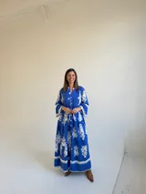 Vestido largo color azul con estampado ornamental en color blanco, escote en V con botones frontales y mangas tres cuartos con volados.
