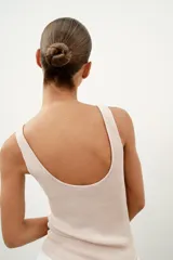 Top de punto canalé en color beige, con escote en pico adornado con una delicada aplicación de encaje blanco y tirantes anchos.
