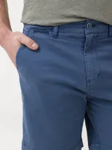 Short de gabardina azul de la marca RKF, modelo Classic, con bolsillos laterales y traseros, tiro medio y cierre frontal con botón y cremallera.