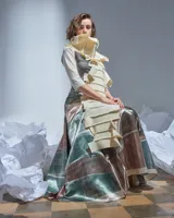 Bufandón de lana merino afieltrada color natural, formado por piezas horizontales unidas que generan una textura continua.