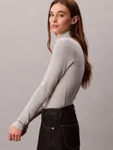 Top de manga larga Calvin Klein color gris melange, con diseño ajustado de corte slim fit, cuello tortuga y pequeño logo bordado en el pecho.