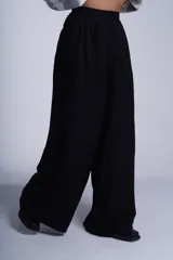Pantalón sastrero negro de corte amplio, con elástico en la cintura trasera y pretina delantera con botón.