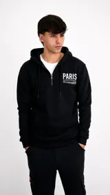 Hoodie negro con cierre frontal parcial, capucha con cordones ajustables y estampa blanca en el pecho con la palabra Paris.