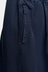 Pantalón de tiro bajo con cintura elástica ajustable mediante cordón, bolsillos delanteros y bolsillos de plastrón en la parte trasera.