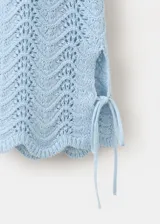 Buzo de punto celeste con diseño recto, detalles calados, cuello redondo y manga larga con cordones ajustables en los puños.