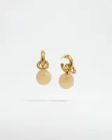 Aros tipo argolla pequeña en metal dorado con textura grabada y dije de piedra esférica color crema desmontable.