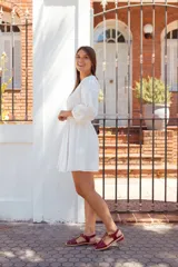 Sandalias planas estilo romano tipo cangrejera, confeccionadas en cuero charolado de color bordó. Presentan diseño de tiras entrelazadas en el empeine, puntera cuadrada, talón cerrado con tira ajustable mediante hebilla metálica dorada y suela plana con pequeño tacón.