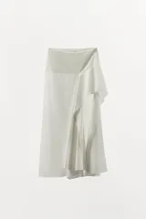 Falda midi de tiro medio confeccionada en hilatura con lino, con diseño de bajo asimétrico y cierre lateral con cremallera oculta.