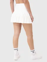 Falda deportiva blanca con short integrado, cintura alta y volados en el ruedo.