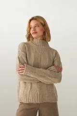 Buzo de tejido de punto industrial color marrón oscuro, con cuello medio y diseño de bloques cuadrados en relieve.