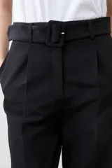 Pantalón de vestir color beige, de corte recto, con pinzas, bolsillos laterales y cinturón con hebilla forrada.
