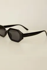Lentes de sol con armazón de policarbonato en color beige y diseño hexagonal, con cristales oscuros con protección UV400.
