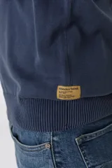 Sweater marrón con cuello mao abotonado y detalle de tejido en los hombros.