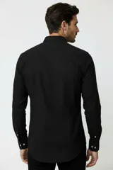 Camisa de viscosa color negro, de manga larga, con cuello camisero y cierre frontal de botones.