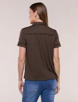 Camisa de manga corta color marrón oscuro, con cuello camisero, alforzas verticales, detalles de puntilla calada y frunces bajo el busto. Cuenta con cierre frontal de botones.