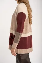 Cardigan abierto de punto con diseño de bloques de color en tonos beige, marrón y bordó. Presenta mangas largas, corte recto y bolsillos frontales aplicados.