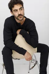 Remera manga larga de corte clásico, confeccionada en tejido tipo waffle negro, con cuello redondo y cartera de botones frontal.
