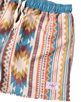 Short de baño de microfibra con estampado geométrico en tonos beige, marrón, naranja y celeste. Tiene cintura elástica con cordón ajustable, dos bolsillos laterales y un bolsillo trasero.