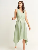 Vestido negro con escote en V y corte irregular con picos en los costados. Incluye lazo de algodón a tono para ajustar en la cintura.