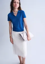 Buzo de punto color azul, con cuello polo y manga corta, de diseño recto.