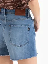 Short de denim azul de tiro medio-alto y silueta relajada, con lavado celeste claro, desgastados suaves y ruedo con acabado al corte.