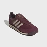 Championes Adidas modelo SL 72 RS, de diseño retro en color bordó con detalles en beige. Confeccionados con base de cuero y superposiciones de gamuza, presentan las icónicas tres rayas laterales, mediasuela de EVA y suela de caucho.