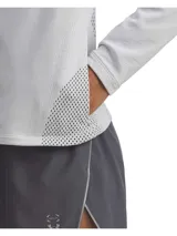 Campera deportiva de cierre completo con cuello alto, confeccionada en tejido de punto jacquard ligero y ultratranspirable. Presenta perforaciones estratégicas para ventilación, bolsillos laterales con cremallera invisible y logotipos reflectantes.