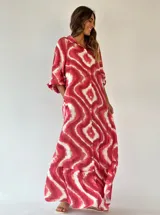 Vestido largo camisero de algodón, con estampado tipo tie-dye en tonos fucsia y blanco, cierre frontal con botones, cuello camisero y mangas largas.